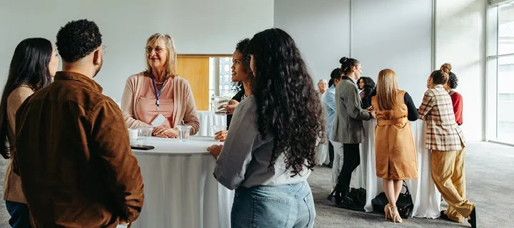 People standing around a registration table at a convention