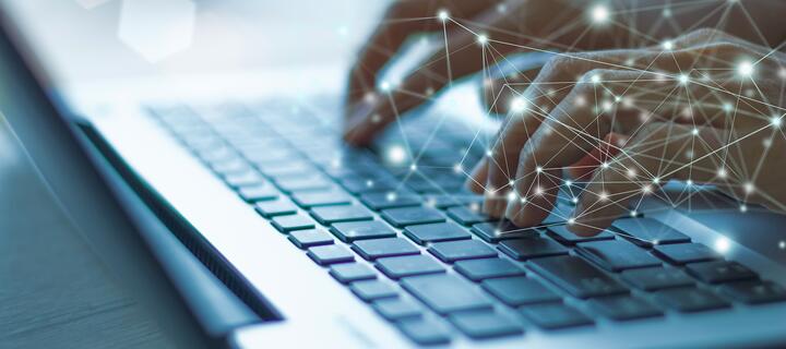 Hands typing on a laptop